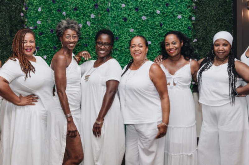 Eight Black women dressed in white posing together
